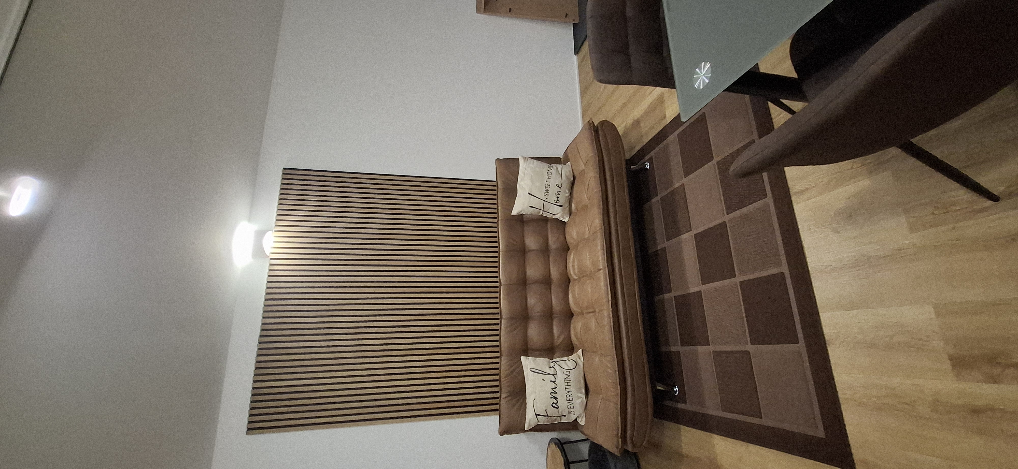 Gemütliches Schlafsofa vor dekorativen Holzpanelen